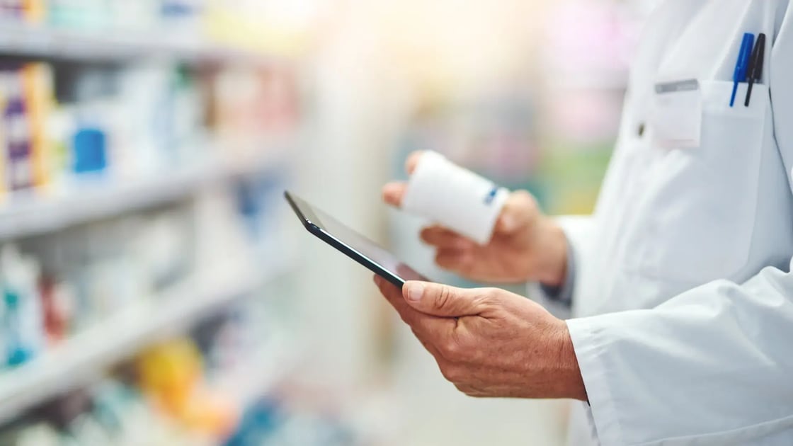 Kädessä lääkepurkki ja matkapuhelin