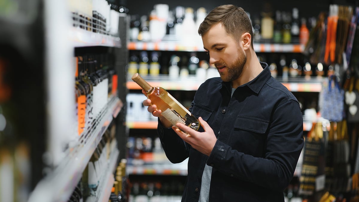 Mies katsoo viinin etikettiä